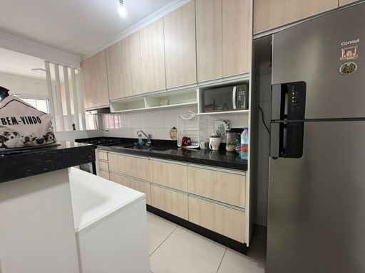 cozinha padrão americana com planejados, ampla pia em granito preta, semi integrada a área de serviço com acesso a varanda gourmet