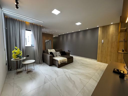 Ampla sala decorada, em porcelanato com ventilação cruzada, teto rebaixado e sistema de iluminação impecável
