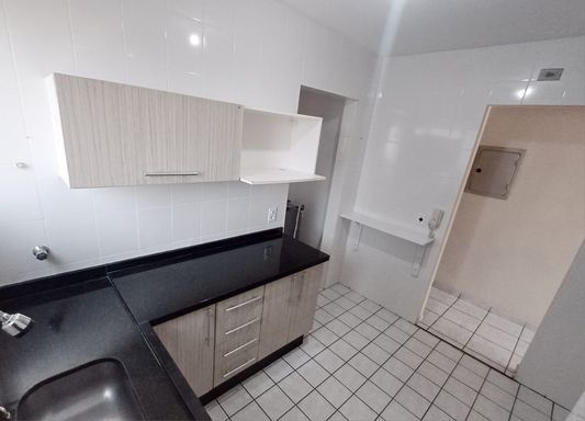 cozinha bem arejada e iluminada com armários planejados e ampla pia em granito preta