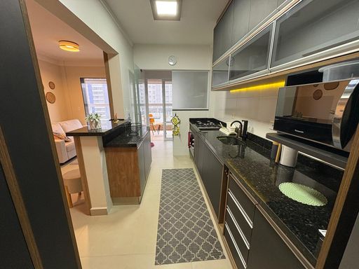 Cozinha ampla com armários planejados, semi integrada a área de serviço e acesso a varanda gourmet envidraçada