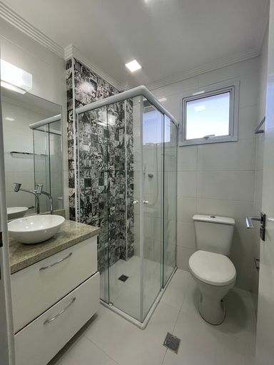 banheiro social arejado com armário planejado e box de vidro