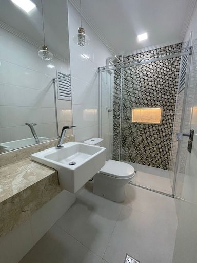 banheiro da suíte com box de vidro e nicho