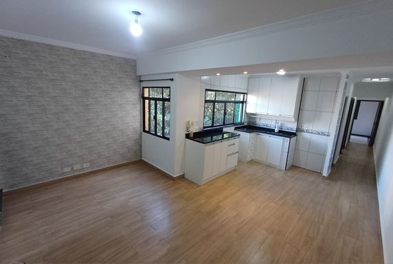 ampla sala 2 ambientes semi integrada a cozinha com armários planejados, bem arejada e vista arborizada