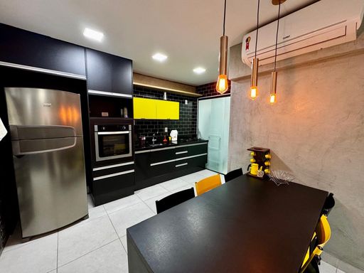 sala semi integrada a cozinha com móveis planejados de primeiríssima qualidade, com acesso a área de serviço com porta de correr de vidro