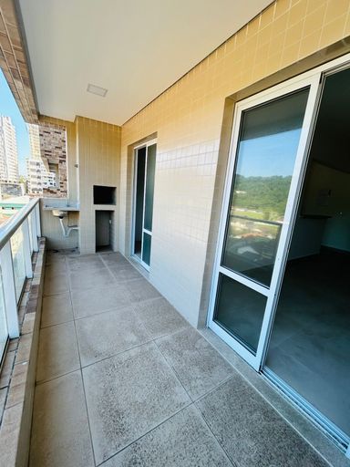 varanda gourmet com churrasqueira e acesso a sala 2 ambientes e a área de serviço