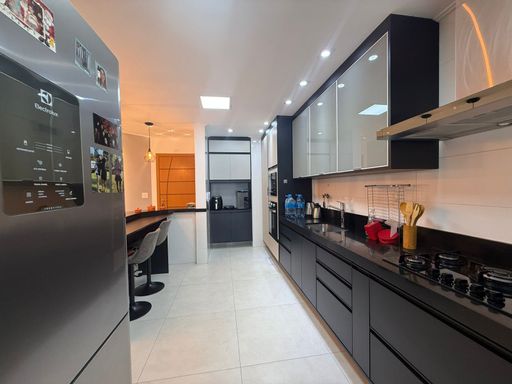 cozinha planejada com móveis de primeiríssima qualidade e ampla pia em granito preta