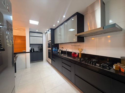 cozinha planejada com móveis de primeiríssima qualidade e ampla pia em granito preta