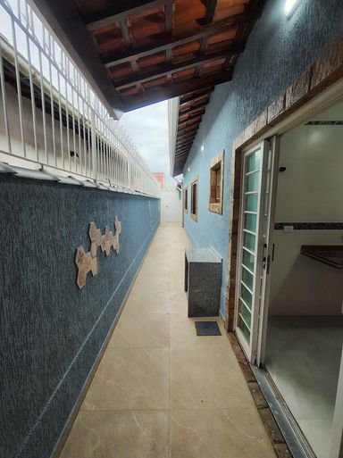 corredor com acesso ao quintal e a churrasqueira a carvão