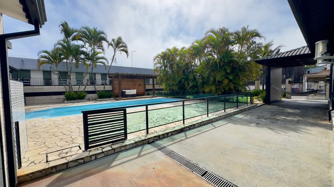 área de piscina com lounge e pergolado