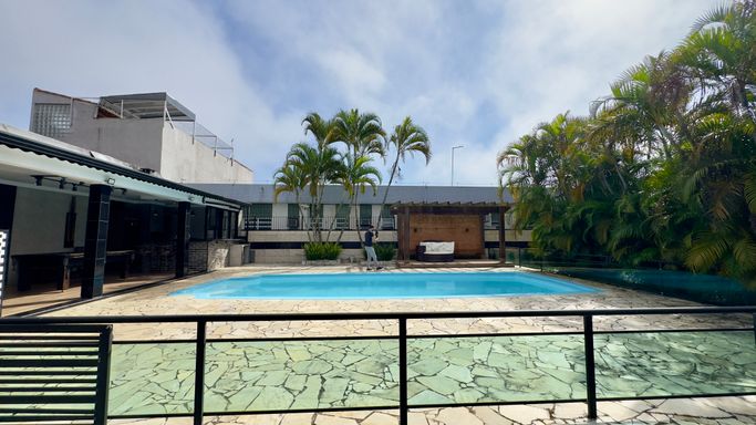 área de piscina com lounge e pergolado
