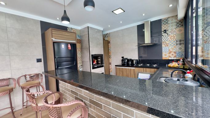 espaço gourmet, com mesa de bilhar, churrasqueira, cozinha completa, 2 banheiros externos, com vista para a piscina.