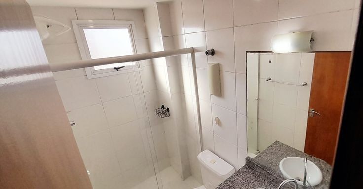 banheiro social arejado com iluminação natural e box de vidro