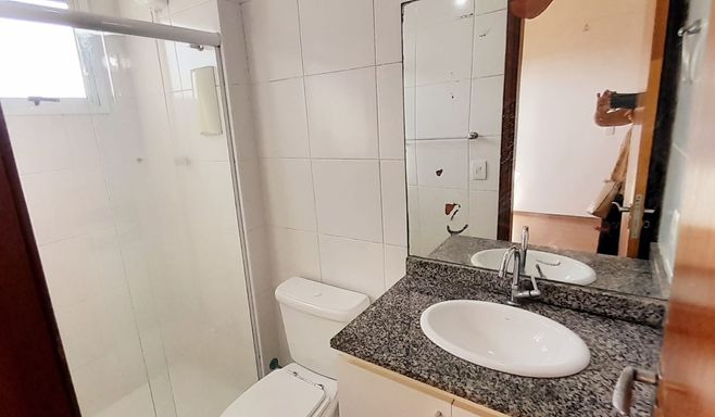 banheiro da suíte arejado com iluminação natural e box de vidro