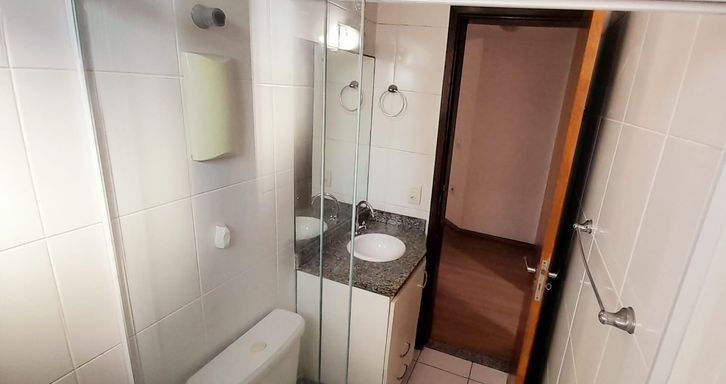 banheiro social arejado com iluminação natural e box de vidro