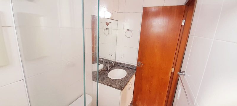 banheiro da suíte arejado com iluminação natural e box de vidro