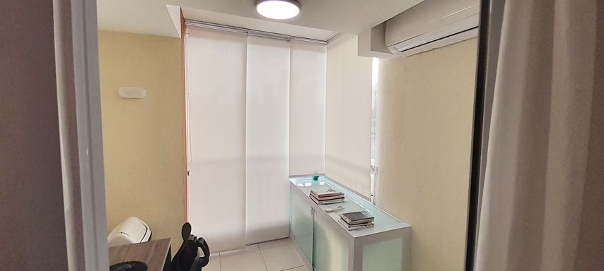 varanda envidraçada transformada em home office, com moveis planejados , cortina blackout e ar condicionado