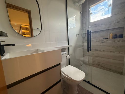 banheiro da suíte bem arejado com nicho e armário planejado