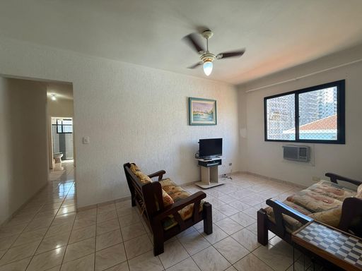 ampla sala com ventilador de teto e acesso aos dormitórios