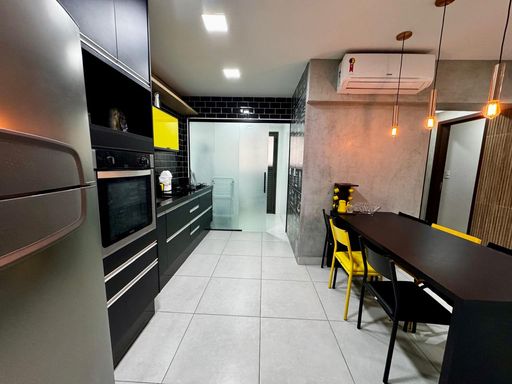 sala semi integrada a cozinha com móveis planejados de primeiríssima qualidade, com acesso a área de serviço com porta de correr de vidro