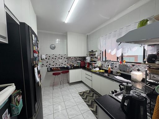 ampla cozinha com janela bem arejada e armários planejados de primeira qualidade