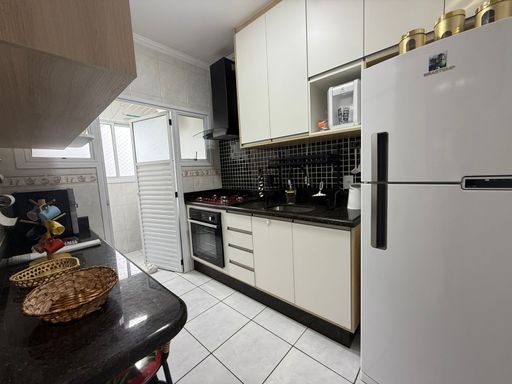 cozinha com armários planejados, com acesso a área de serviço com porta