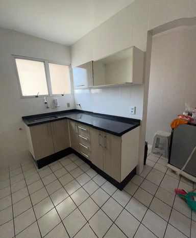cozinha bem arejada e iluminada com armários planejados e ampla pia em granito preta