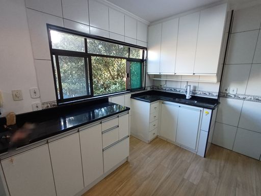 cozinha com armários planejados, bem arejada e vista arborizada