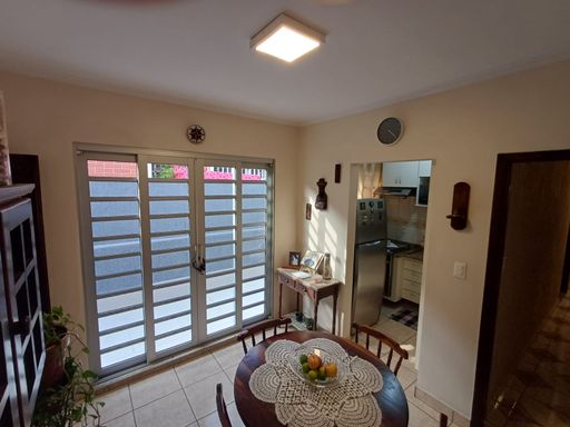 sala de jantar com acesso ao quintal externo e a cozinha planejada