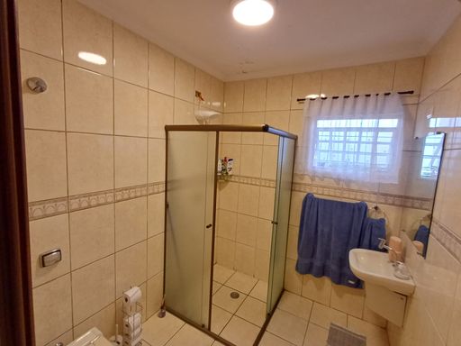 amplo banheiro da suíte bem arejado com box de vidro