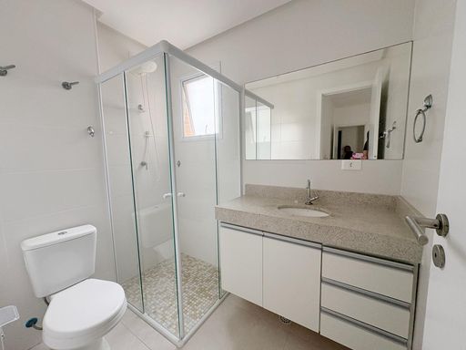 banheiro da  suíte bem arejado com armário planejado e box de vidro