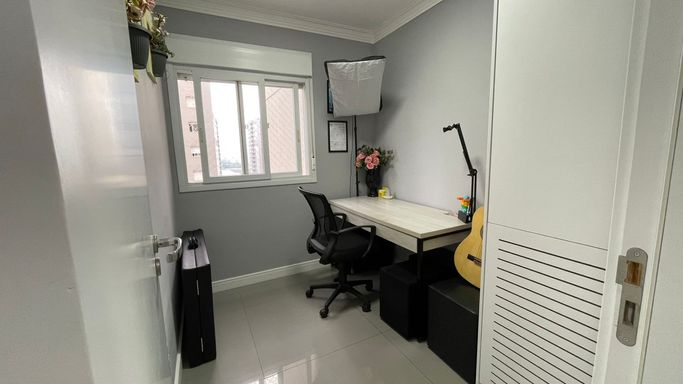 terceiro dormitório com espaço home office, móveis planejados e janela estilo persiana blackout