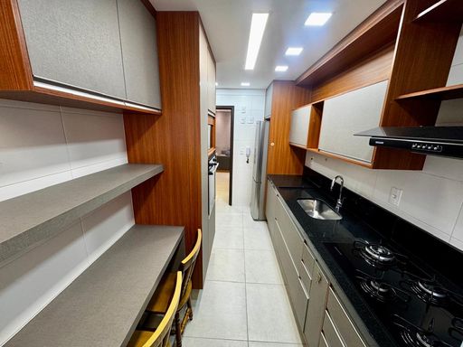 cozinha com ampla pia em granito preta e armários planejados de primeiríssima qualidade