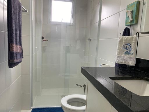 banheiro da suíte com armário planejado e box blindex, bem arejado