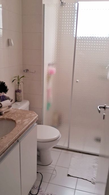 banheiro social com ventilação natural, armário planejado e box blindex