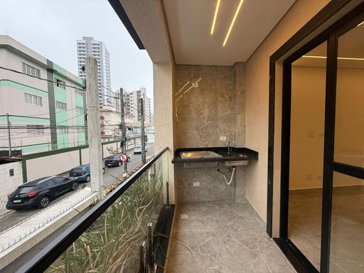 sacada gourmet com churrasqueira, vista de frente  para rua e acesso a sala