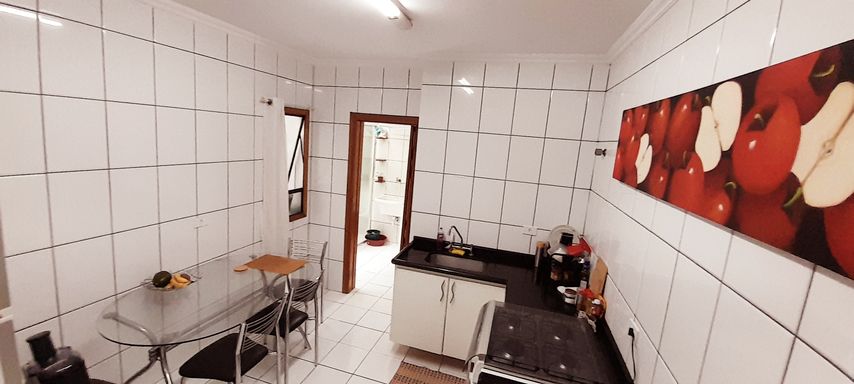 ampla cozinha com pia em granito em L preta e armários planejados