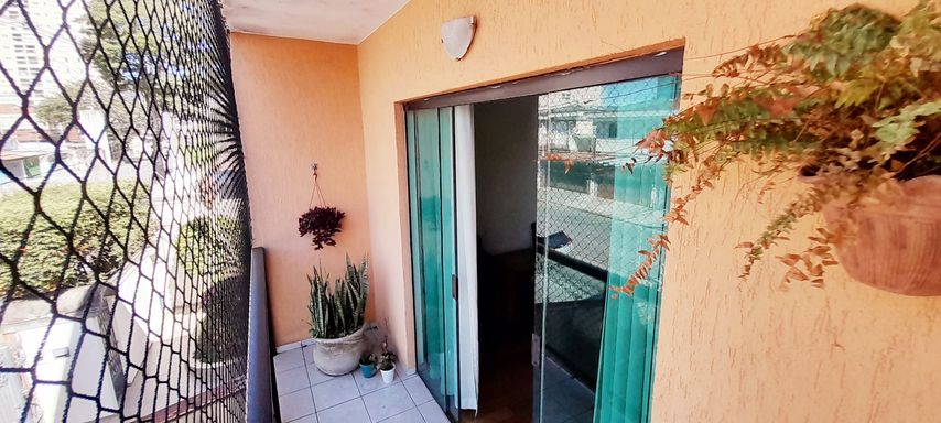 ampla sacada com porta de correr de vidro e tela de proteção, vista privilegiada de frente para rua principal