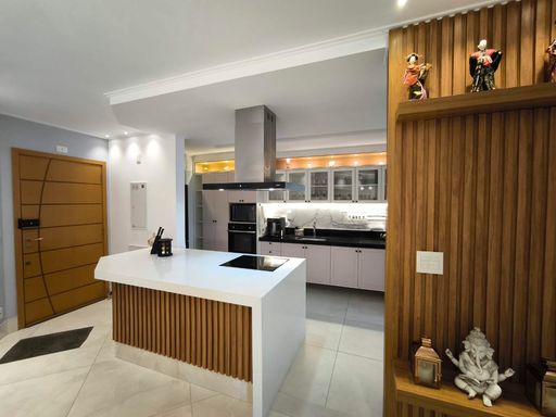Cozinha integrada com planejados e projeto de iluminação