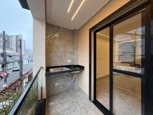 sacada gourmet com churrasqueira, vista de frente  para rua e acesso a sala