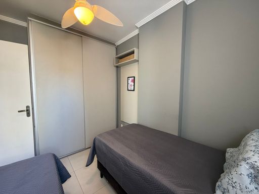 dormitório com armário planejado e ampla janela, bem arejado