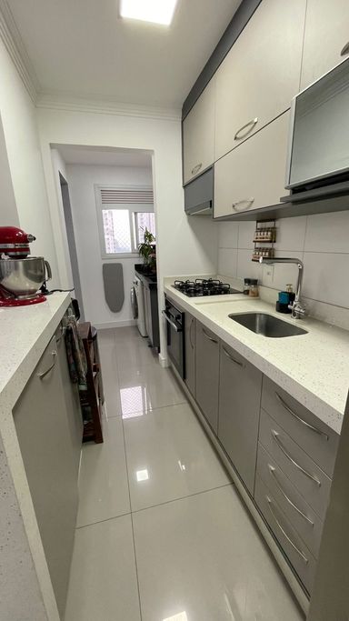 cozinha clean estilo americana com balcão, armários planejados de primeira qualidade, semi integrada a área de serviço bem arejada