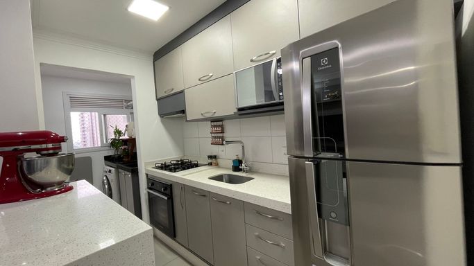 cozinha clean estilo americana com balcão, armários planejados de primeira qualidade, semi integrada a área de serviço bem arejada