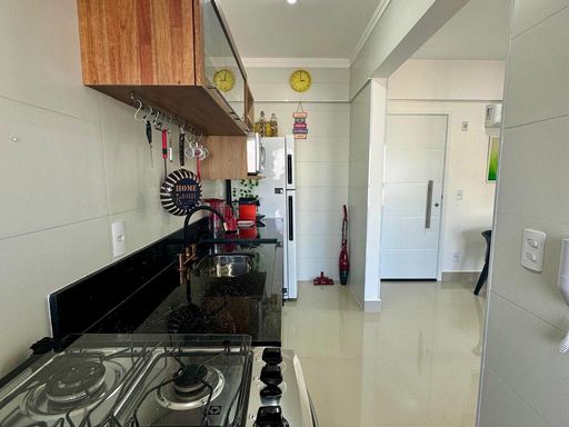 cozinha com ampla pia em granito preta semi integrada a sala 2 ambientes