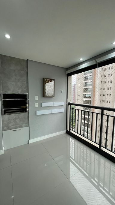 ampla varanda gourmet envidraçada com churrasqueira a carvão e cortina blackout, piso em porcelanato