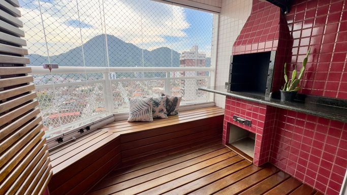 Varanda gourmet em formato de deck com churrasqueira a carvão e vista livre