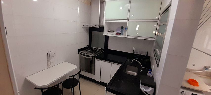 cozinha com armários planejados e ampla pia em L de granito preta