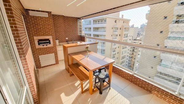 ampla varanda gourmet envidraçada com tela de proteção, churrasqueira, acesso a sala 2 ambientes e a área de serviço