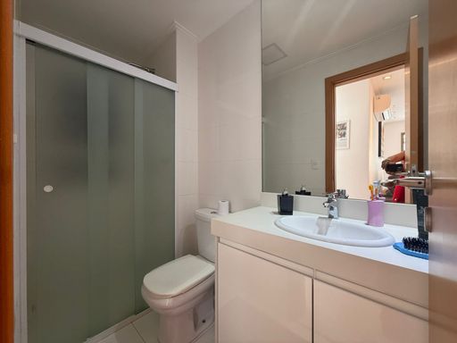 banheiro social com box de vidro e armário planejado