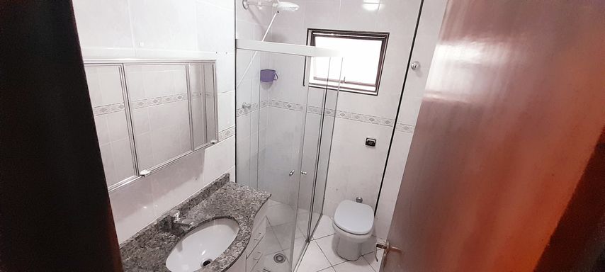 banheiro social com armário planejado, box blindex e ventilação natural