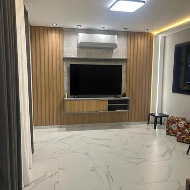 sala em porcelanato com teto rebaixado e sistema de iluminação em LED com total requinte.